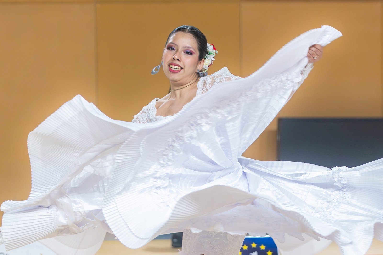 Bailarina de marinera norteña sonriendo mientras levanta una falda blanca